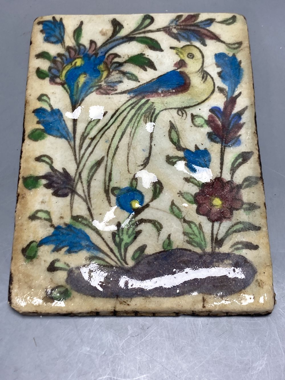 An English porcelain flower painted plaque, c.1830, 16.5 x 23cm and a Persian Qajar tile